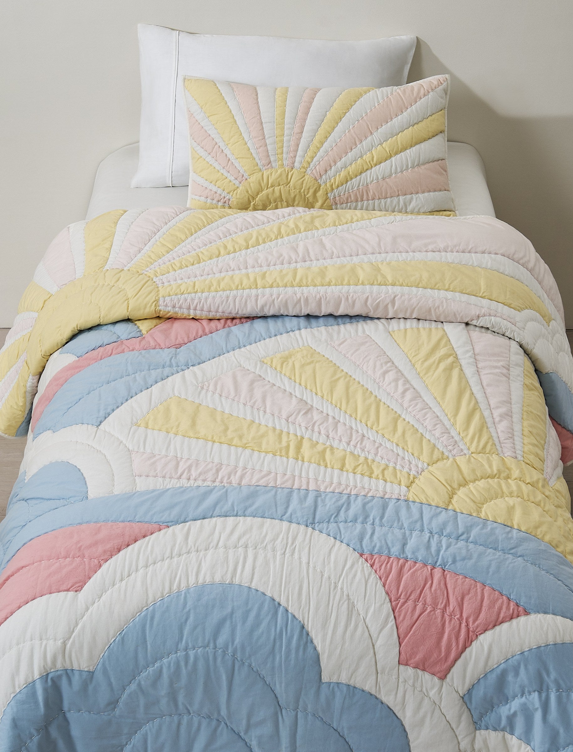 Sunrise Glow kids AC quilt on a bed
