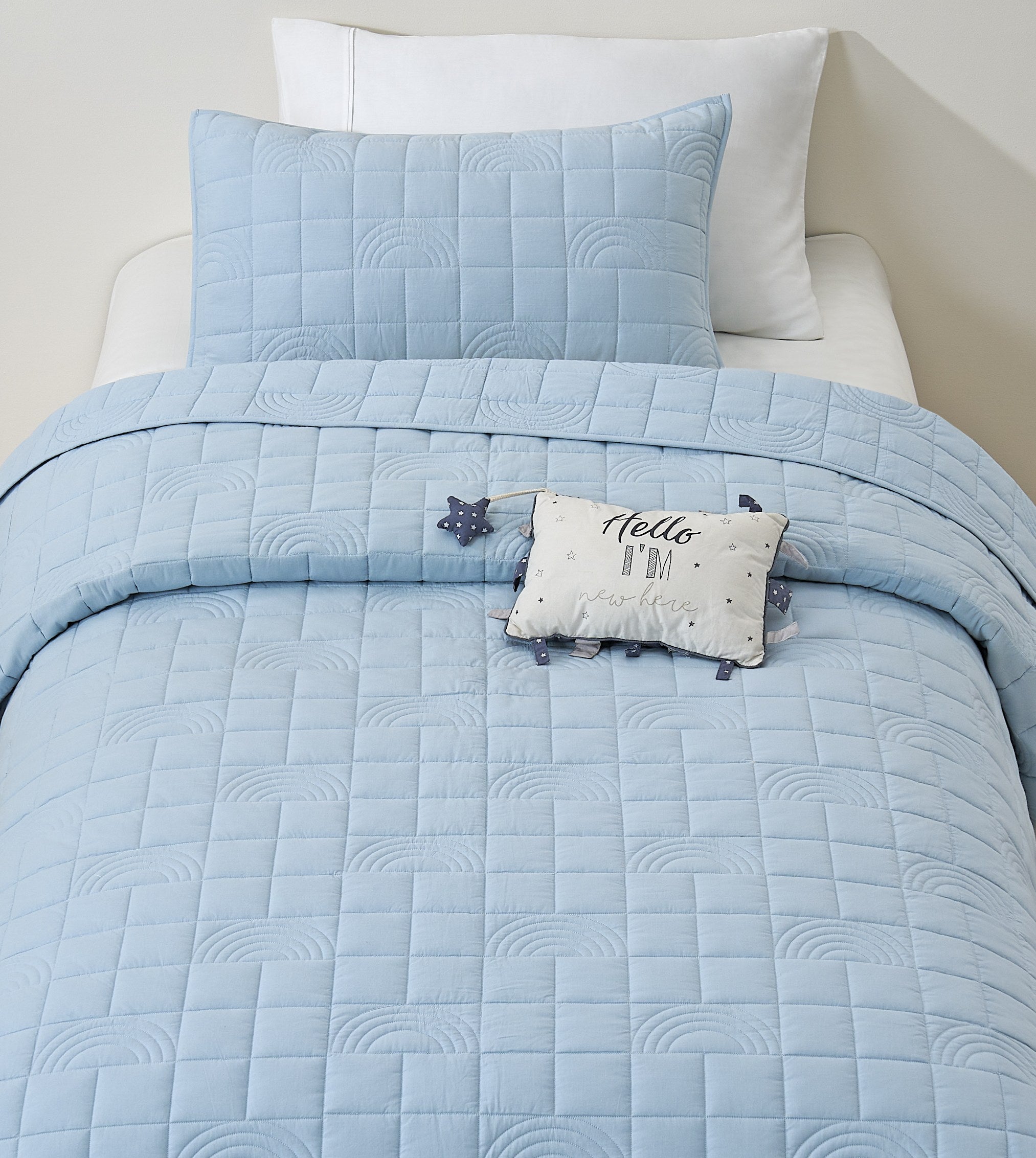 Blue Rainbow kids AC quilt on a bed
