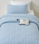 Blue Rainbow kids AC quilt on a bed