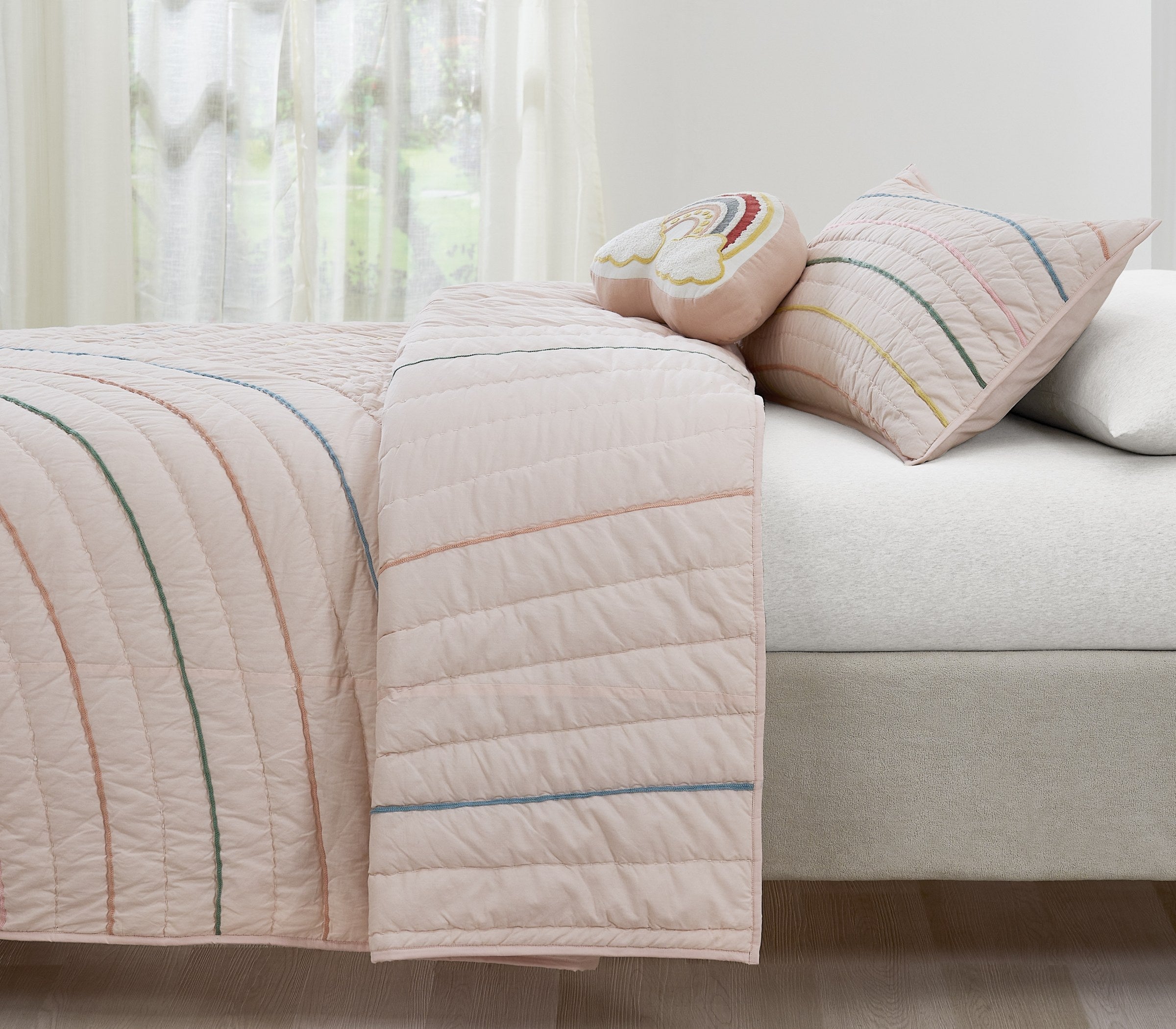 Hush Rainbow kids AC quilt styled in a bedroom